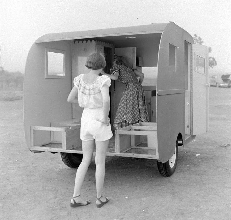 Early travel trailer interior, women exploring, 1930s