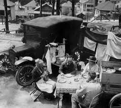 Family dining beside their vehicle, 1920s